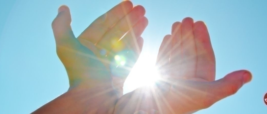erhobene H&auml;nde, durch die das Sonnenlicht strahlt